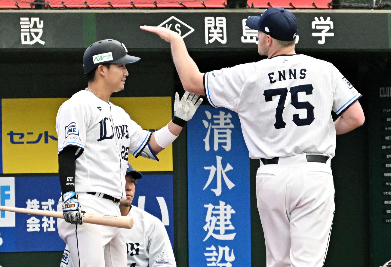 西武対中日　2回裏西武1死一、三塁、中犠飛を放った古賀（左）はベンチ前でエンスからねぎらわれる（撮影・滝沢徹郎）