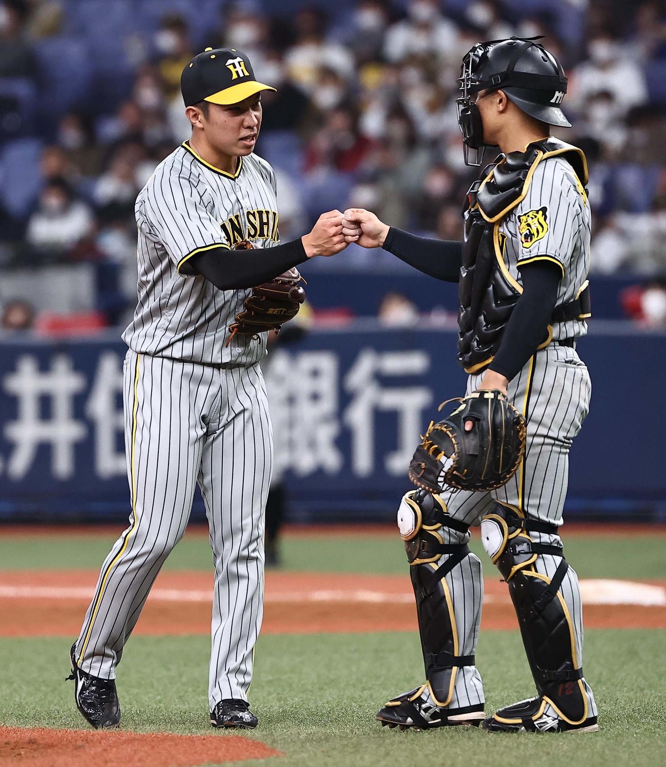 オリックス対阪神　9回に登板し1イニングを無失点に抑えた石井（左）は坂本とグータッチをする（撮影・上田博志）