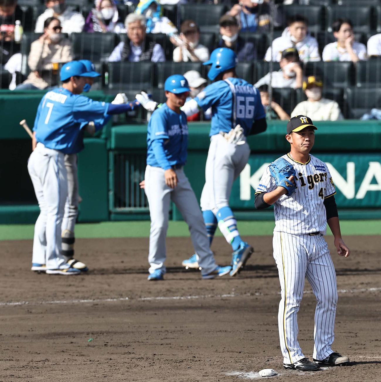 阪神対日本ハム　5回表日本ハム2死三塁、桐敷（右）は万波（右から2人目）に左越え2点本塁打を浴びる（撮影・上田博志）