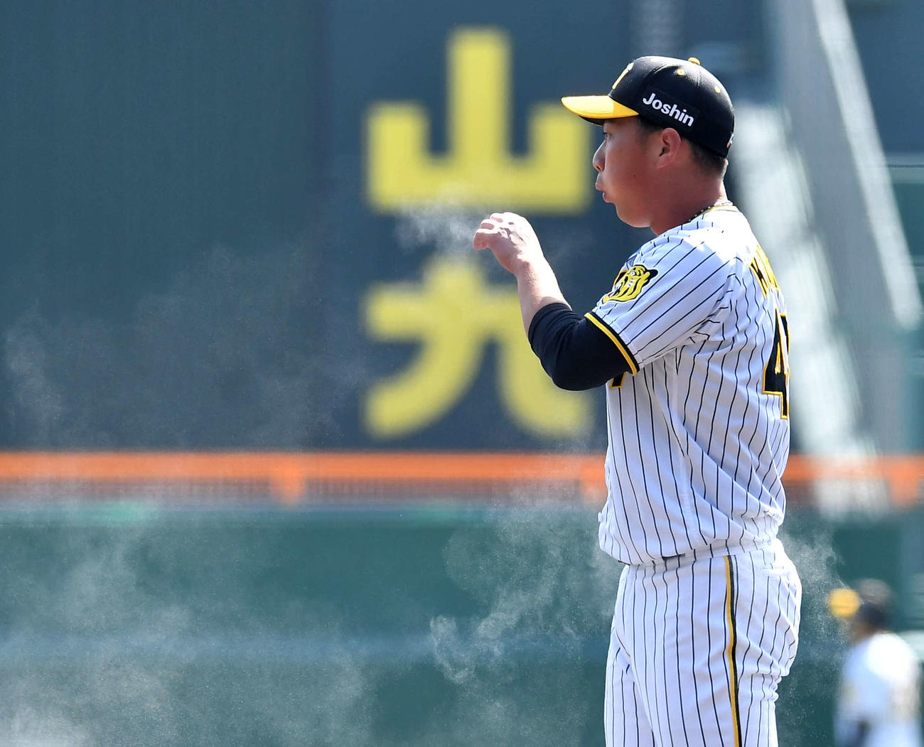 阪神対日本ハム　1回表日本ハム無死、矢沢を二ゴロに抑え、手につけたロジンを吹き飛ばす桐敷（撮影・岩下翔太）