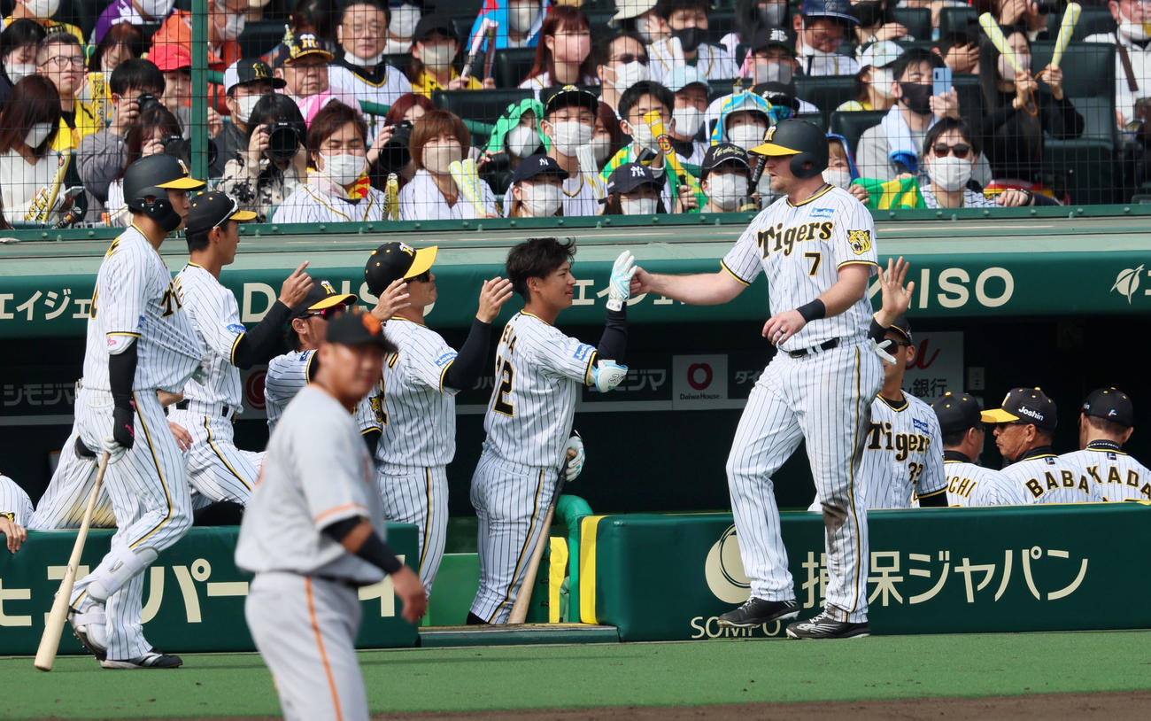 阪神対巨人　4回裏阪神1死一、三塁、ノイジーは板山の野選で生還し、ナインに迎えられる（撮影・加藤哉）