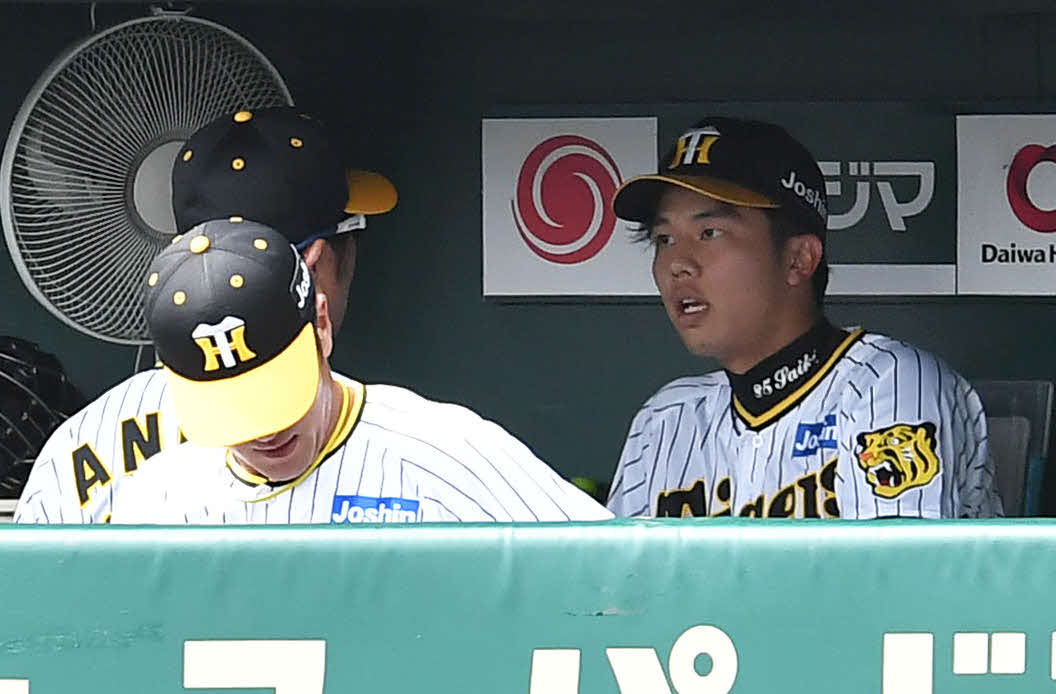 阪神対巨人　3回表を抑え、ベンチで安藤コーチ（後方左）と話す才木（撮影・岩下翔太）