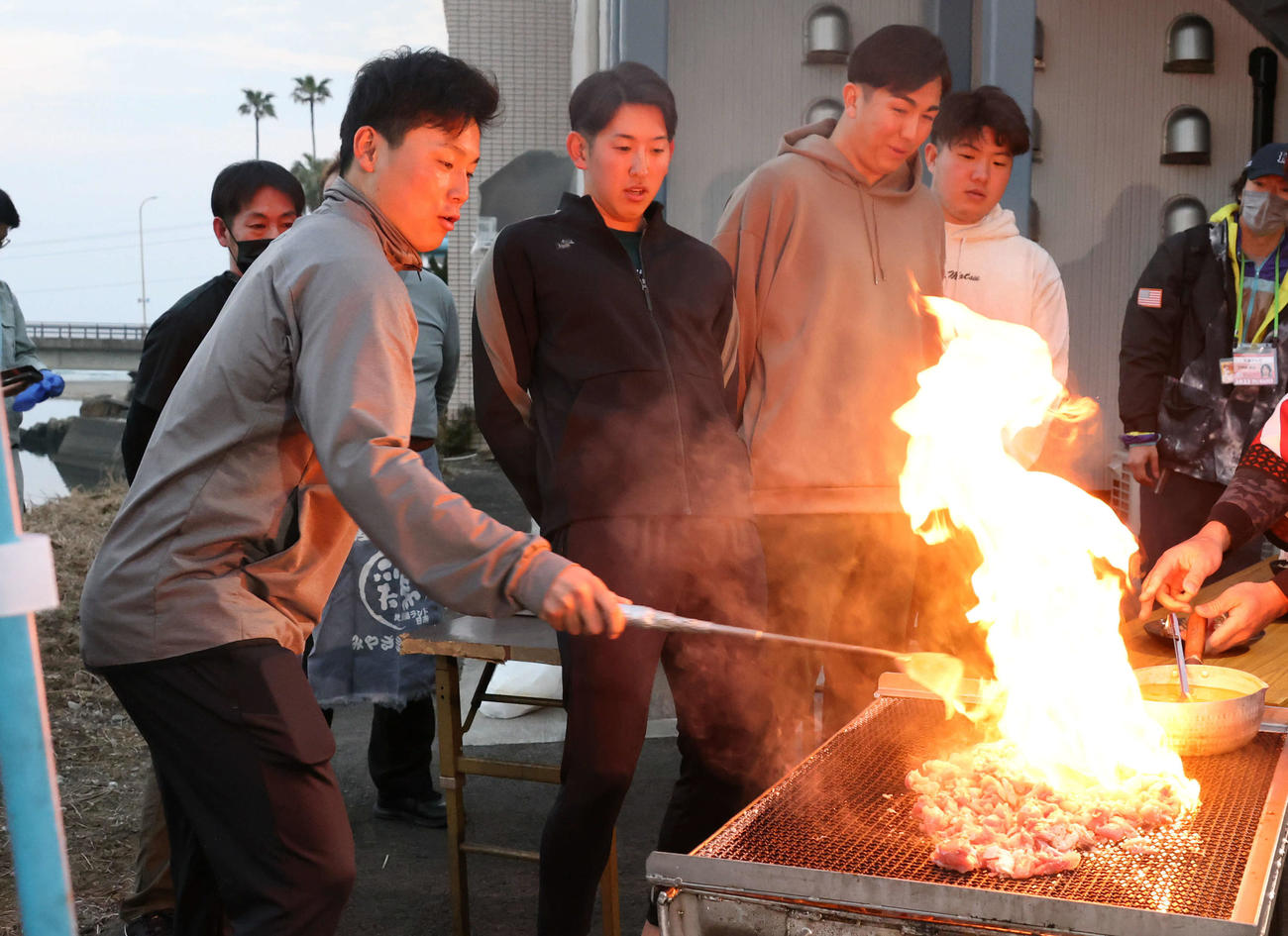 地鶏を焼いて立ち上がる炎に驚く広島の選手たち。左から栗林、遠藤、ケムナ、松本（23年2月3日撮影）