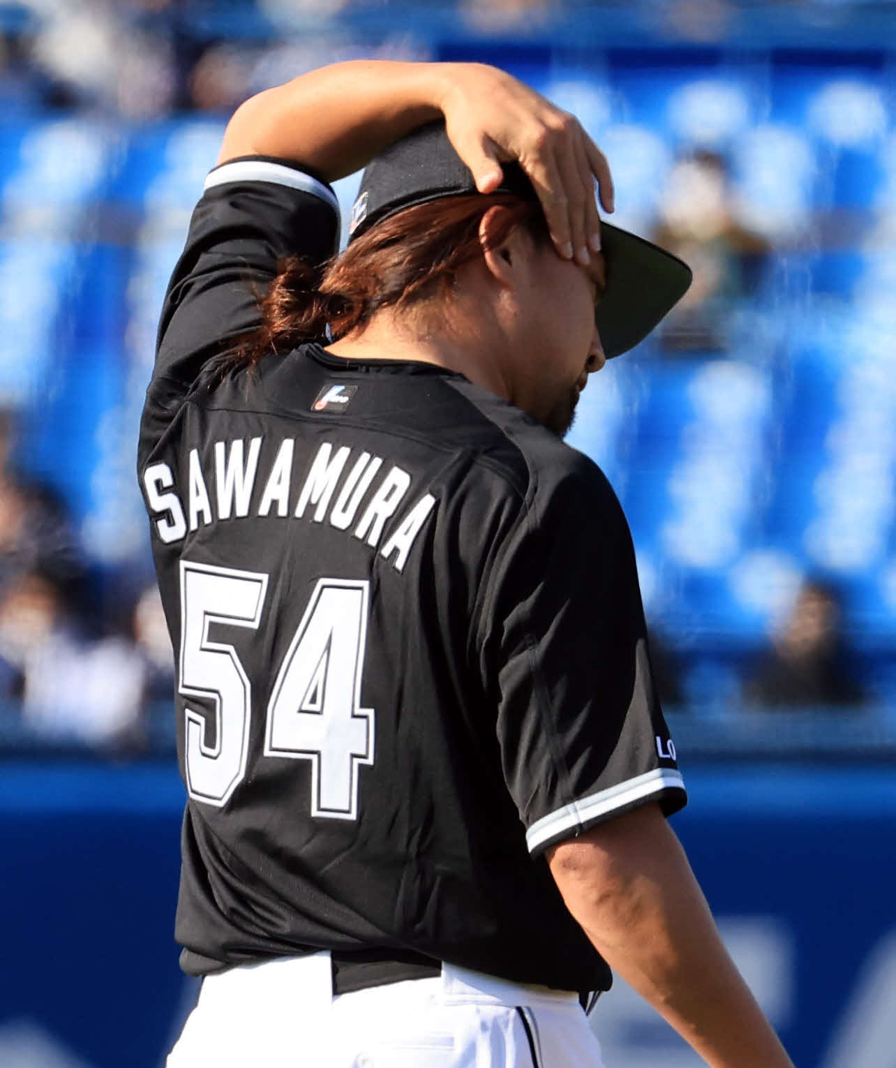 ヤクルト対ロッテ　6回裏ヤクルトの攻撃で登板した沢村は、結んだ髪の毛を整える（撮影・浅見桂子）