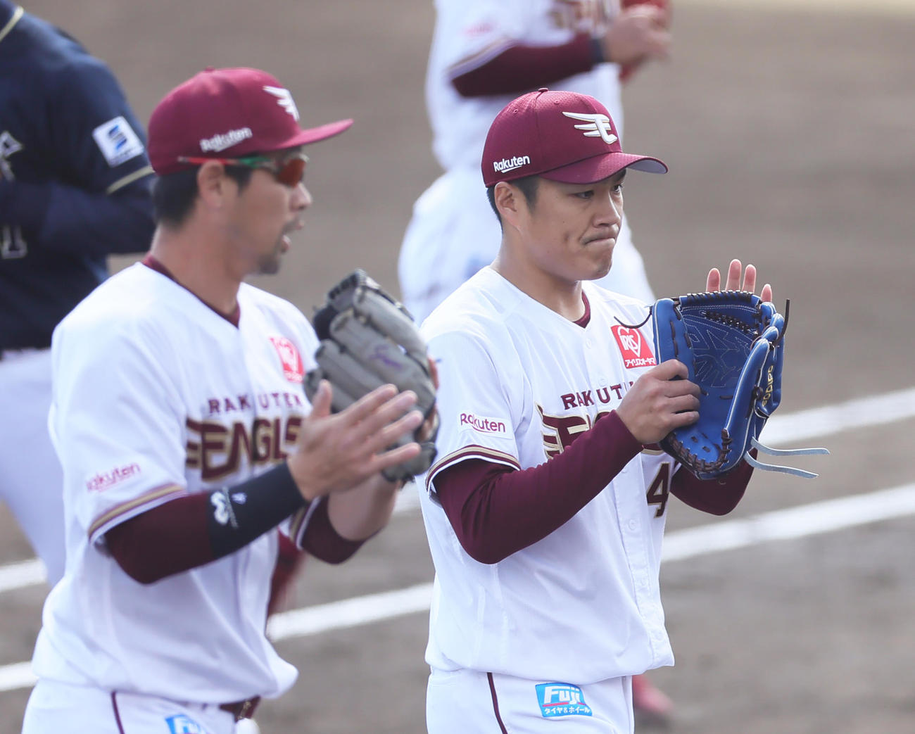楽天対オリックス　2回、無失点で終えグラブをたたきベンチに戻る楽天先発の則本（右）。左は阿部（撮影・足立雅史）