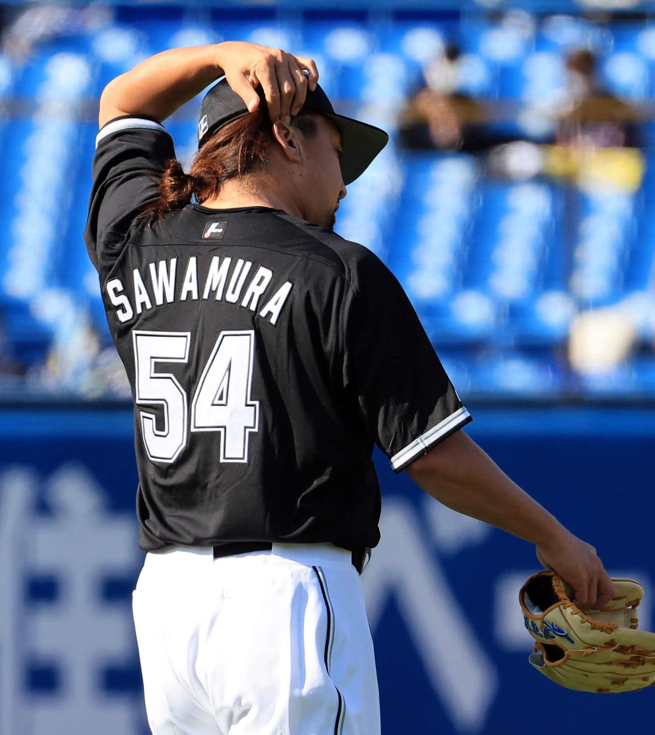 ヤクルト対ロッテ　6回裏ヤクルトの攻撃で登板した沢村は、結んだ髪の毛を整える（撮影・浅見桂子）