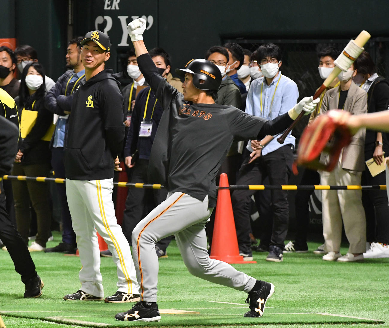 ソフトバンク対巨人　試合前、ソフトバンク長谷川コーチ（左）と談笑しながら熱男ポーズを見せる巨人松田（撮影・岩下翔太）