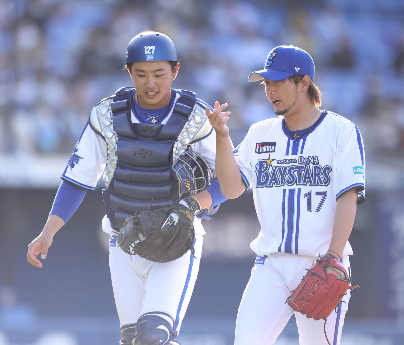 阪神とのオープン戦で、阪神の攻撃を抑え言葉を交わしながらベンチに戻る上甲凌大（左）と三嶋（2023年3月14日撮影）