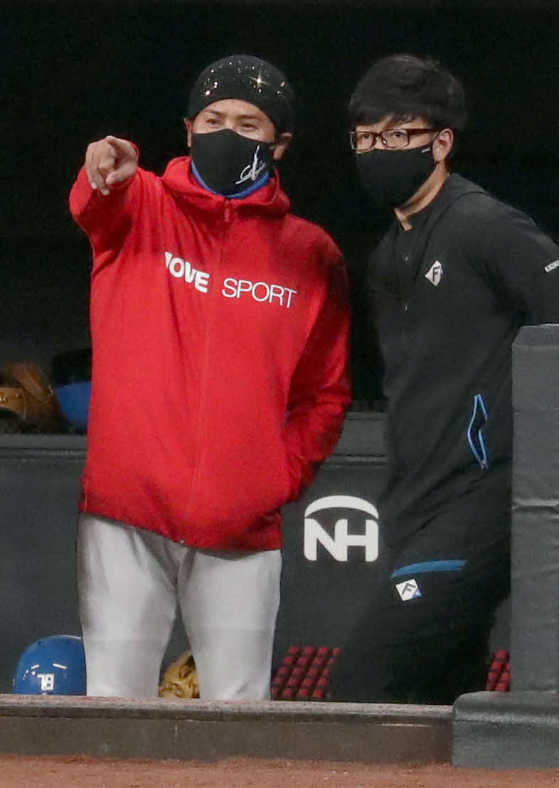 グラウンドを指さす日本ハム新庄監督（左）（撮影・佐藤翔太）