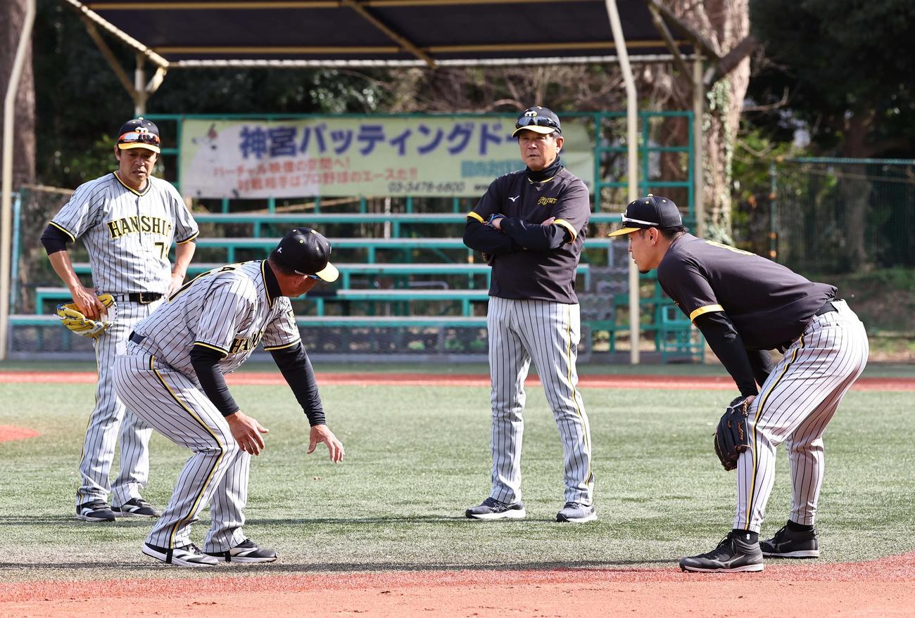 左から藤本コーチ、馬場コーチ、平田ヘッドコーチから守備指導を受ける佐藤輝（撮影・上田博志）