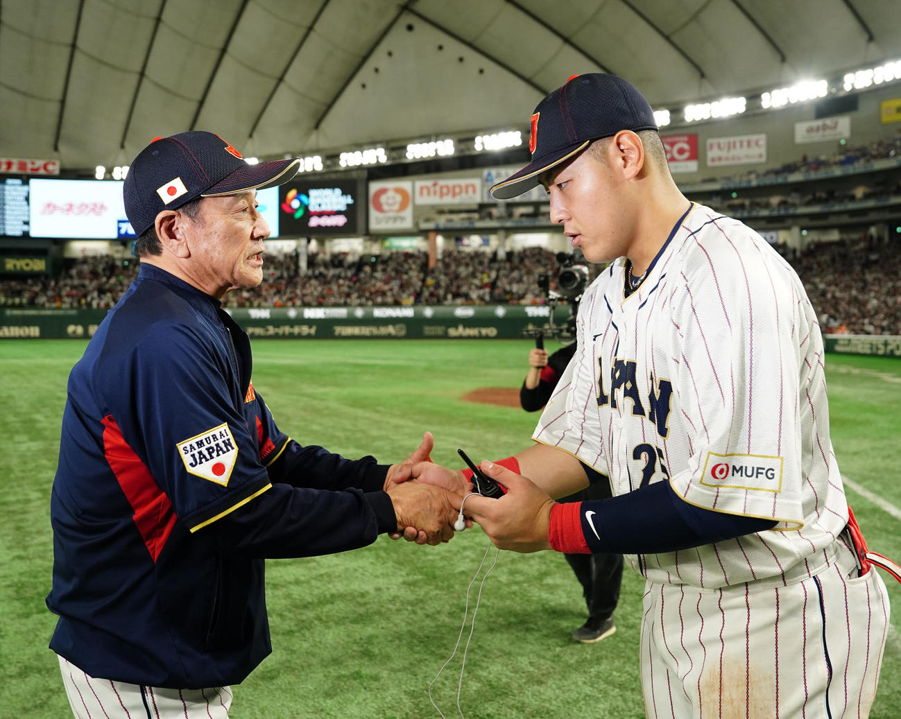 日本対イタリア　試合後、栗山監督（左）と握手を交わす岡本（撮影・江口和貴）