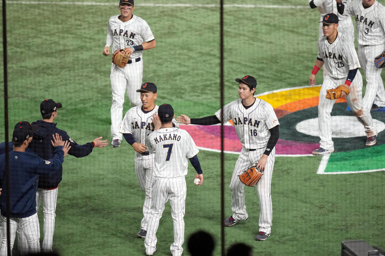 日本対イタリア　4回表を終え、この回に好守を見せた吉田（左）を迎える大谷（撮影・狩俣裕三）