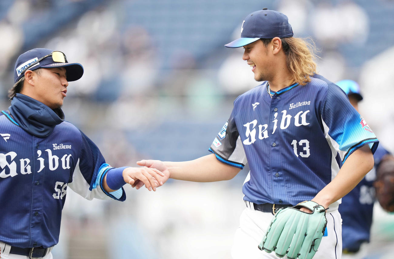 ロッテ対西武　4回裏を終え、好守を見せた二塁手佐藤（左）を笑顔で迎える西武高橋（撮影・鈴木みどり）