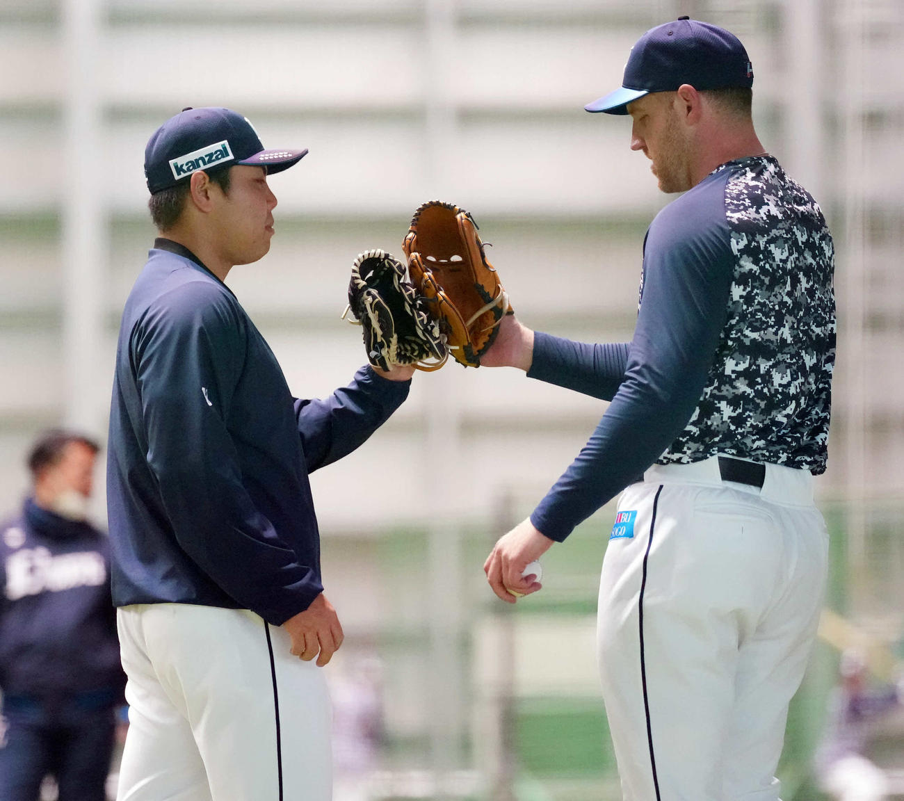 室内練習場でのキャッチボールを終え、タッチを交わす西武平良（左）とエンス（撮影・鈴木みどり）