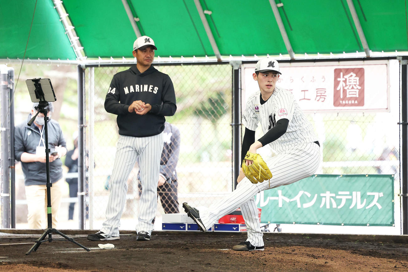ブルペン投球するロッテ佐々木朗（右）を見守る黒木投手コーチ（2023年2月4日撮影）