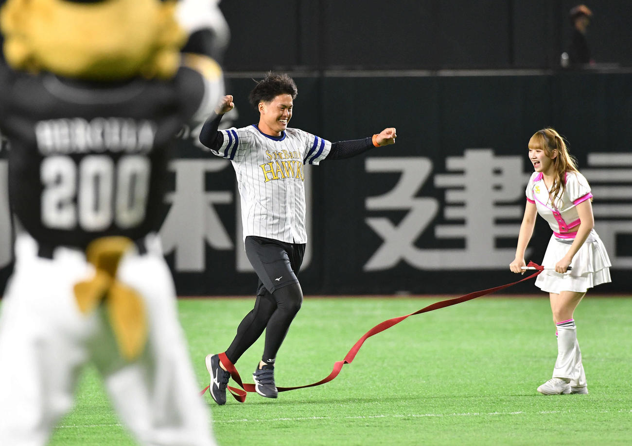 ソフトバンク対DeNA　センターからセレモニアルピッチのマウンドへ激走し、笑顔でガッツポーズしながらゴールする、西宮神社福男選びで今年の一番福となった植本亮太さん（撮影・岩下翔太）