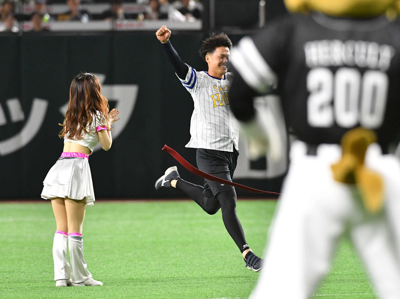 ソフトバンク対DeNA　センターからセレモニアルピッチのマウンドへ激走し、笑顔でガッツポーズしながらゴールする、西宮神社福男選びで今年の一番福となった植本亮太さん（撮影・岩下翔太）