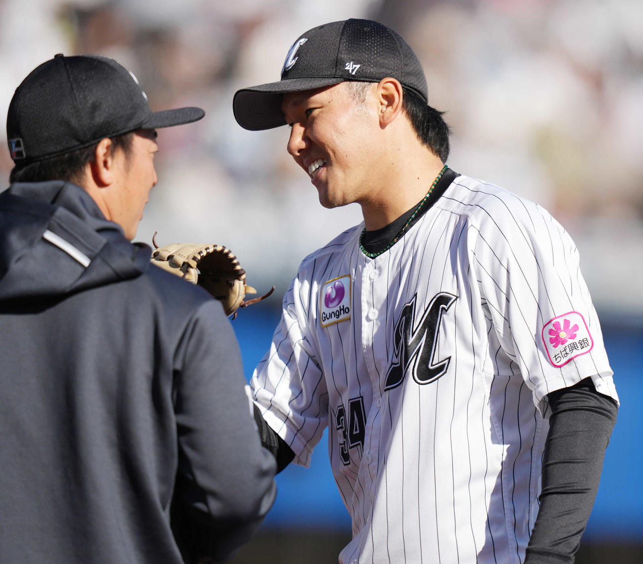 ロッテ対西武　8回表を終え、美馬（左）と笑顔でタッチを交わすロッテ高野（撮影・鈴木みどり）
