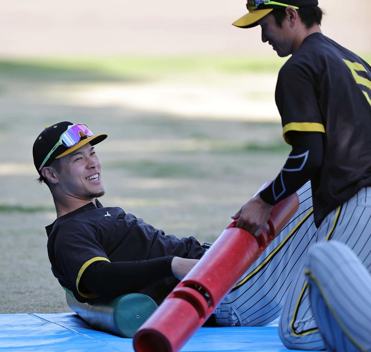近本（右）と談笑する佐藤輝（撮影・上田博志）