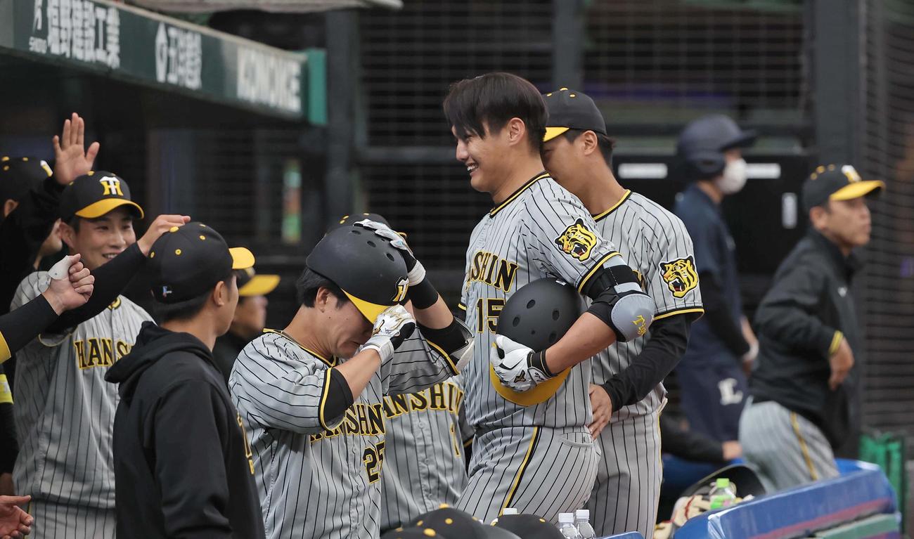 西武対阪神　3回表阪神2死、代走を送られた西純（中央右）はナインの出迎えに笑顔を見せる。右は岡田監督（撮影・上田博志）