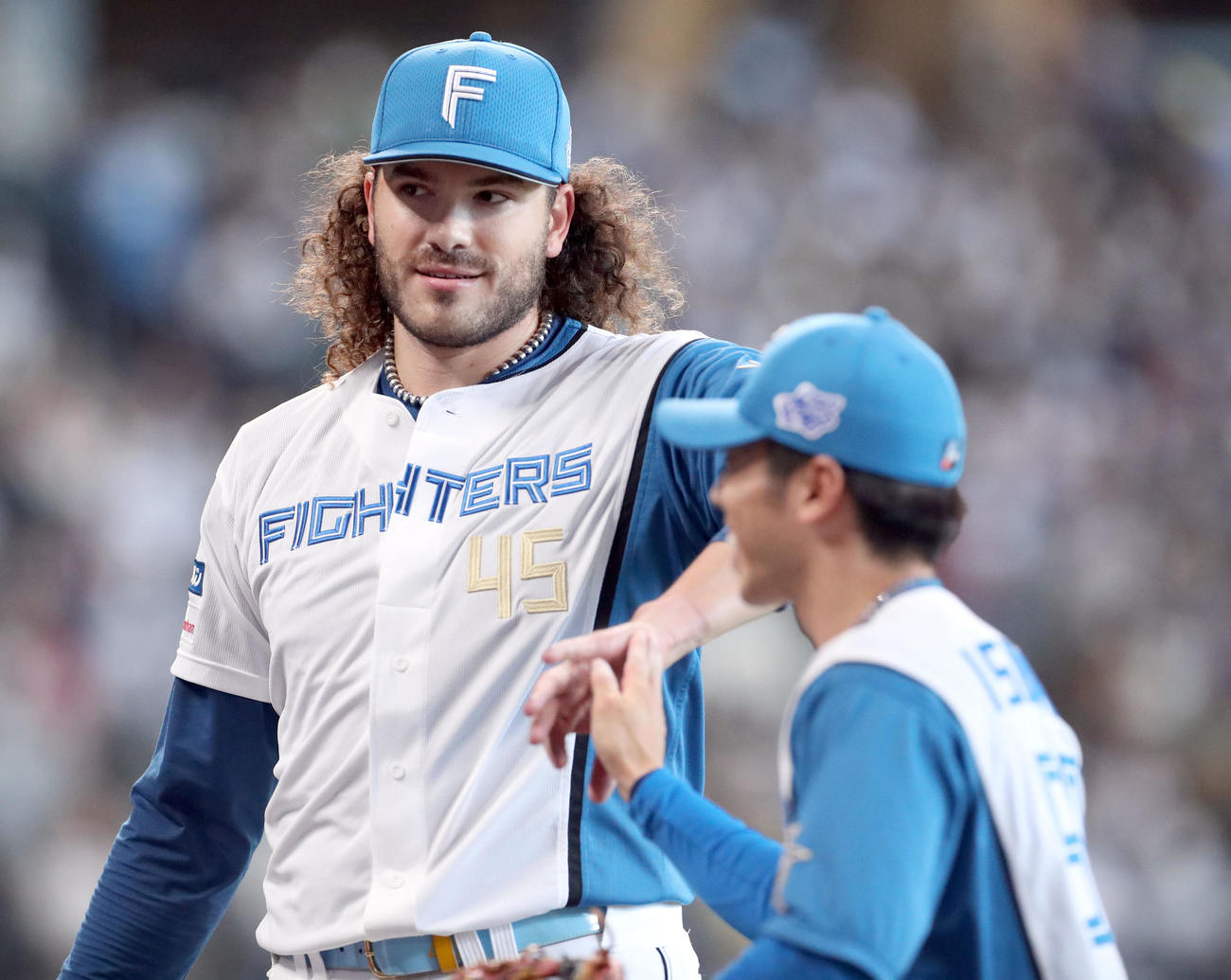 日本ハム対ソフトバンク　2回表終了後、ポンセ（左後方）は五十幡を笑顔で出迎える（撮影・佐藤翔太）