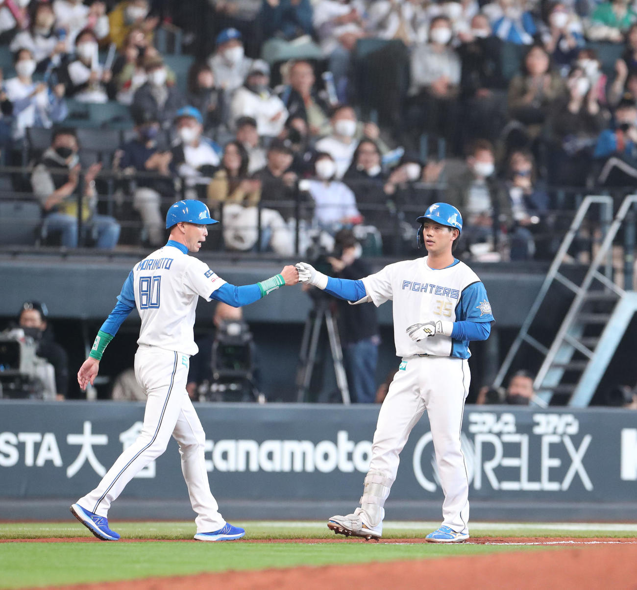 日本ハム対ソフトバンク　6回裏日本ハム無死満塁、先制となる適時二塁打を放ち森本コーチ（左）とグータッチを交わす福田光（撮影・佐藤翔太）