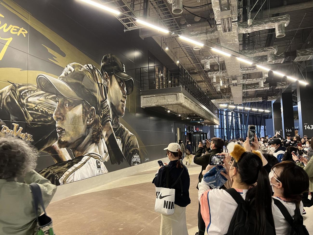 タワー11前の壁画を撮影する来場客（撮影・石井翔太）