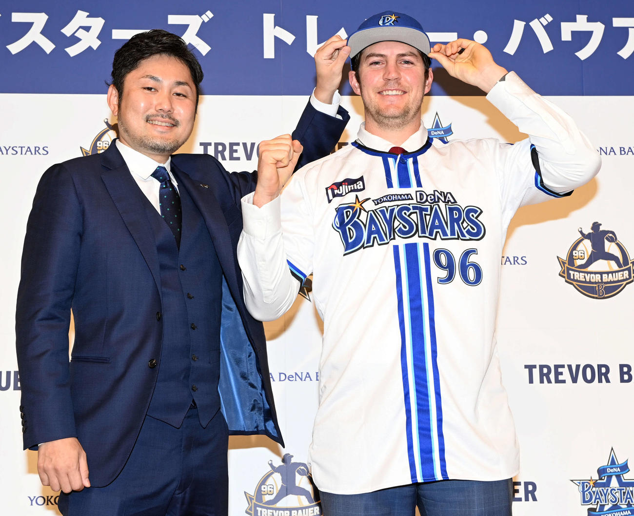 笑顔でポーズを決めるDeNAトバウアー。左は萩原チーム統括本部部長（撮影・たえ見朱実）