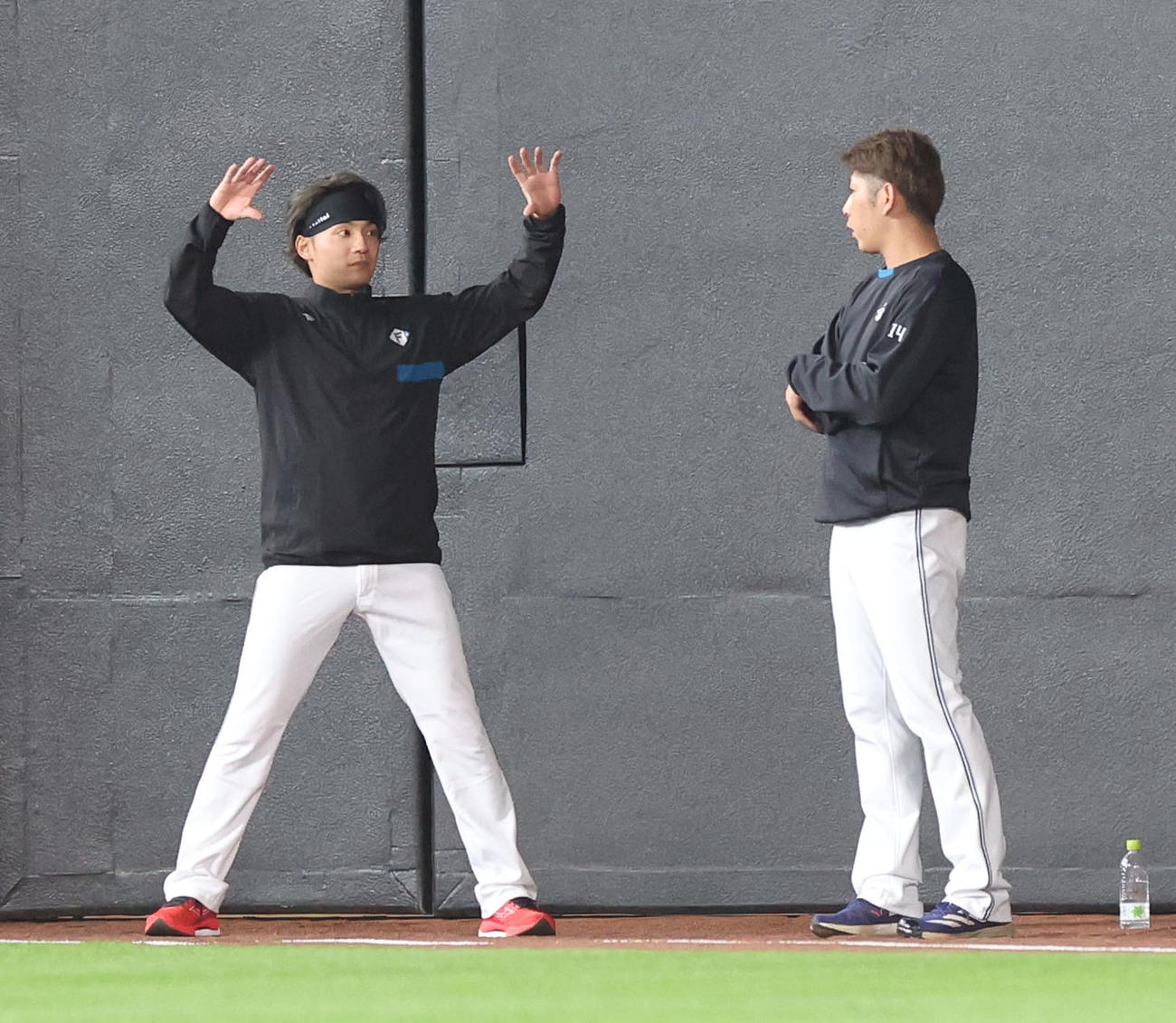 日本ハム対ヤクルト　試合前、会話する日本ハム伊藤（左）と加藤貴（撮影・佐藤翔太）