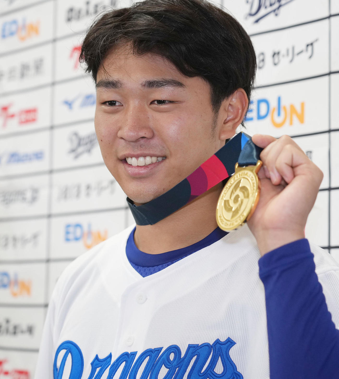 会見を終えWBC優勝金メダルを手に明るい表情でポーズを決める高橋宏（撮影・森本幸一）