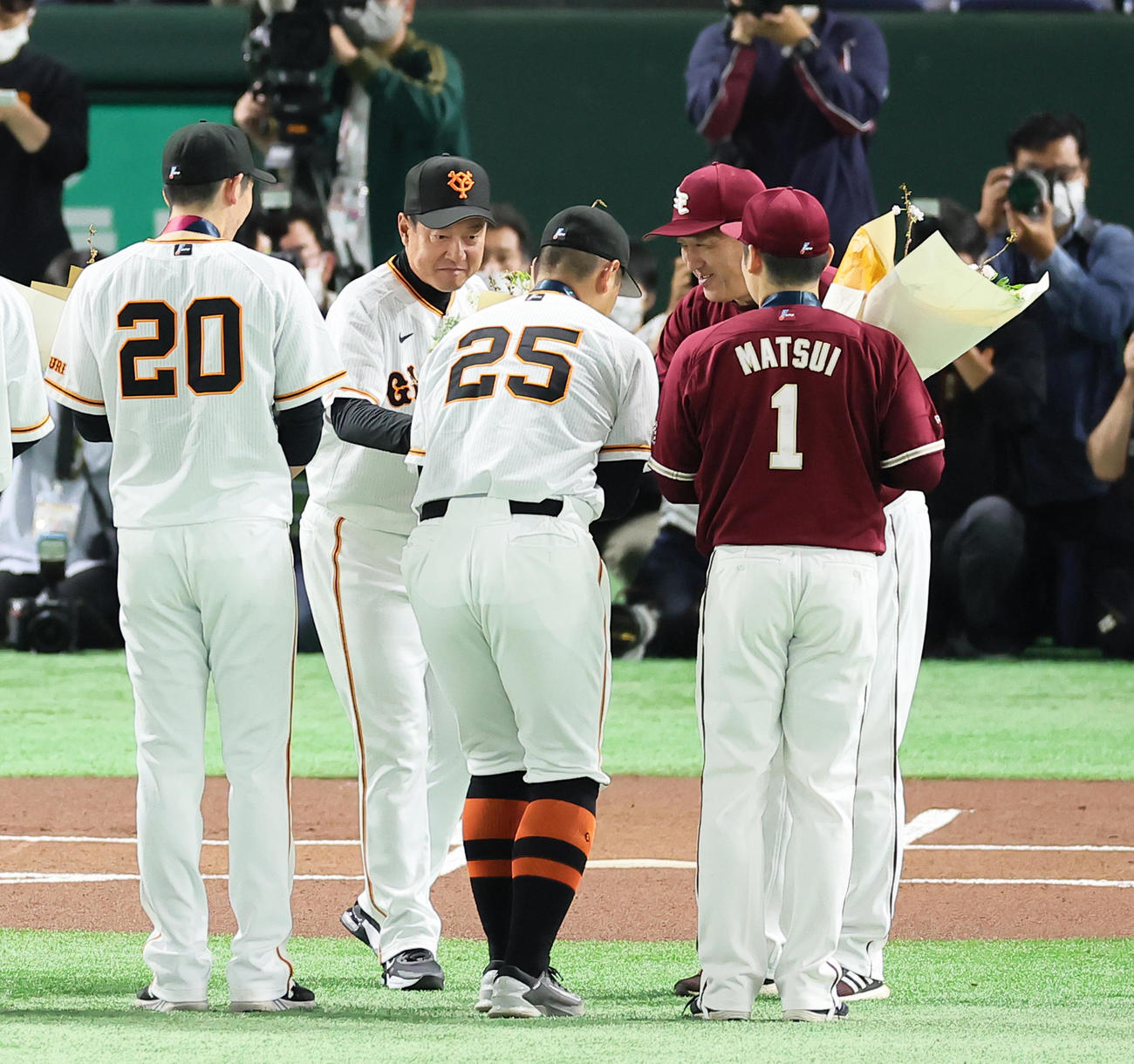 試合前、侍ジャパン優勝セレモニーで巨人原監督（左から2人目）、楽天石井監督（同4人目）から花束を受け取る巨人の戸郷（左）、岡本和（中央）、楽天松井裕（撮影・足立雅史）