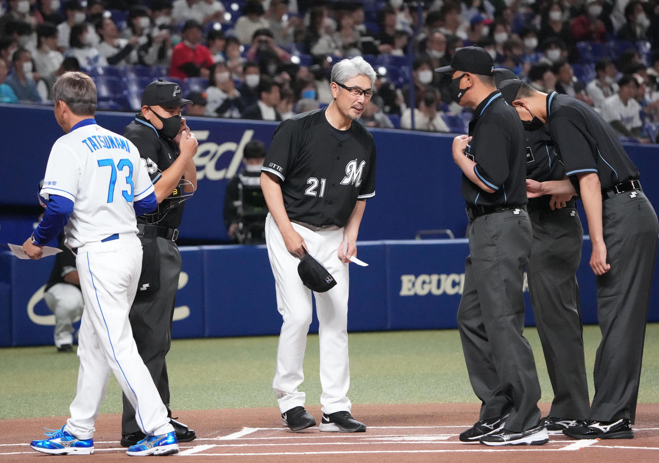 試合前、中日立浪監督とメンバー表を交換し審判団にあいさつするロッテ吉井監督（中央）（撮影・森本幸一）
