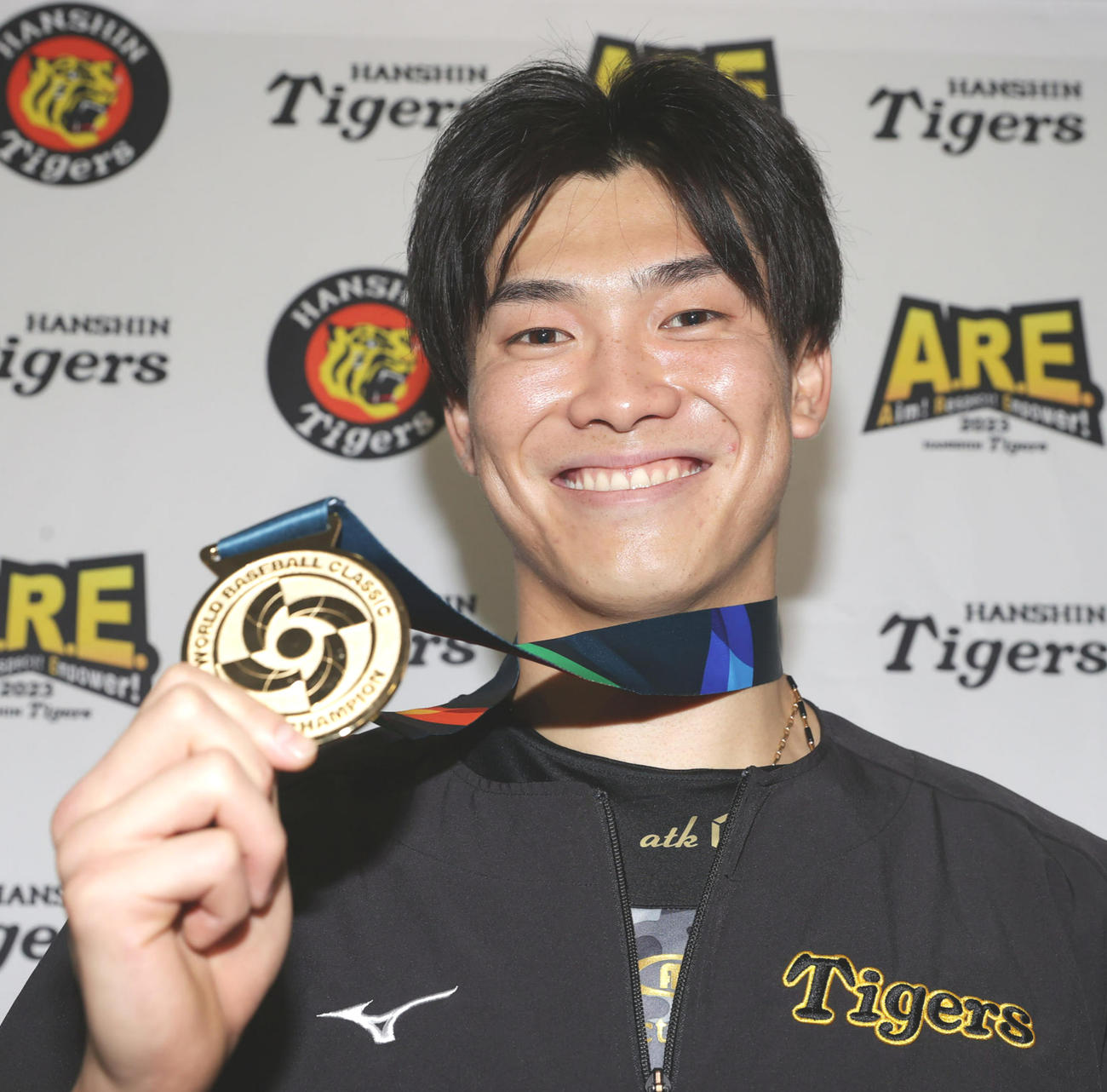 阪神対オリックス　WBCの優勝メダルを手に笑顔を見せる阪神湯浅（撮影・前田充）
