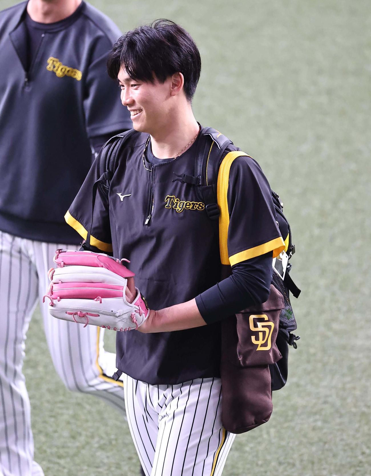 阪神対オリックス　パドレスのボールケースを持ってグラウンドに入る湯浅（撮影・上田博志）