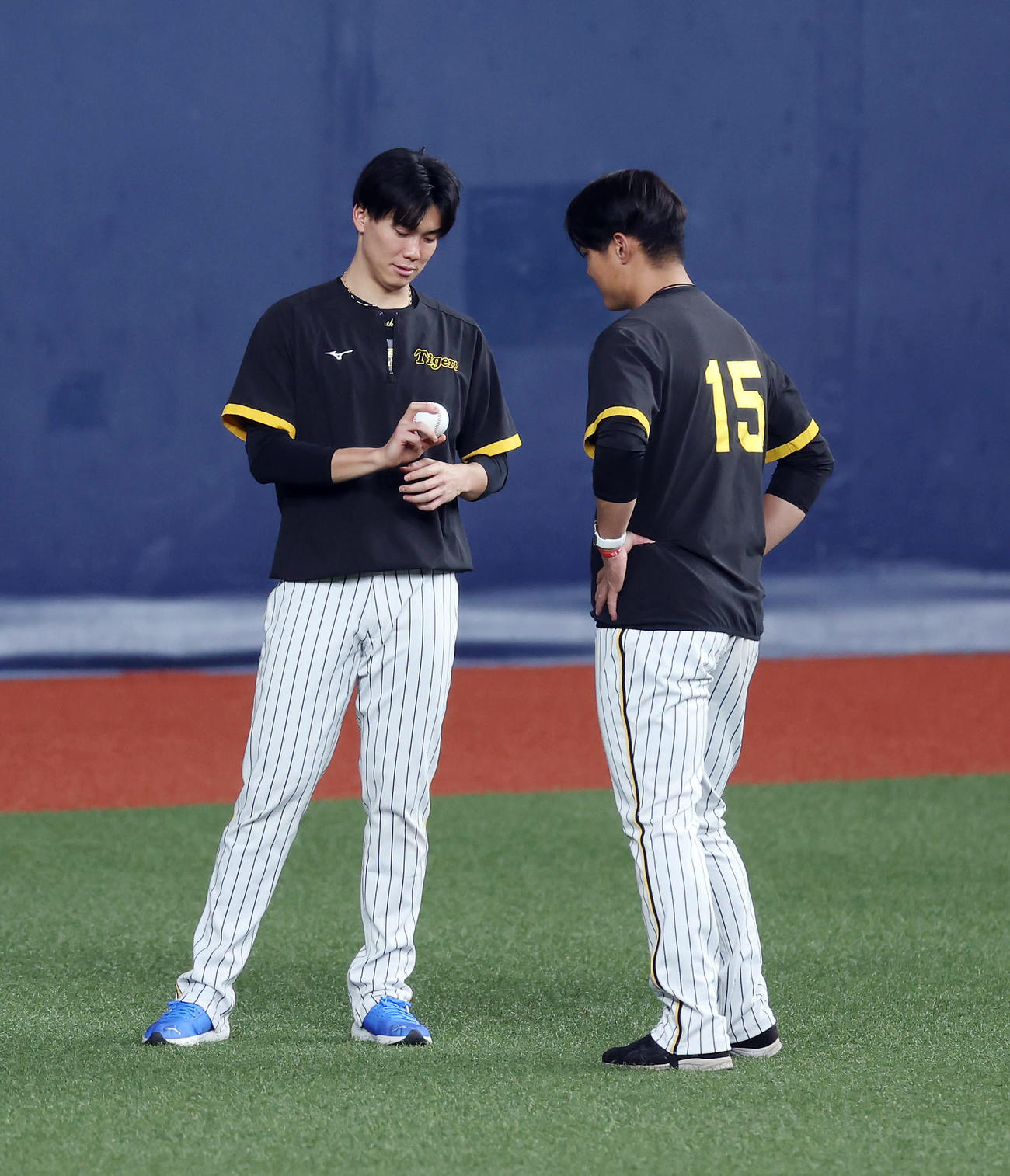 阪神対オリックス　阪神西純（右）にボールの握りを見せる湯浅（撮影・前田充）