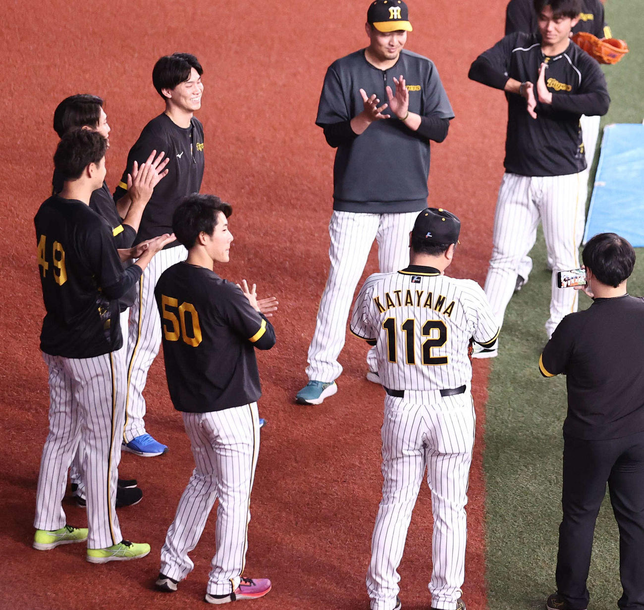 阪神対オリックス　WBC優勝から1軍合流した湯浅（左から3人目）に拍手を送る阪神ナイン（撮影・上田博志）