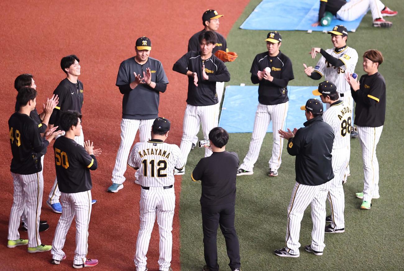 阪神対オリックス　WBC優勝から1軍合流した湯浅（左から3人目）に拍手を送る阪神ナイン（撮影・上田博志）