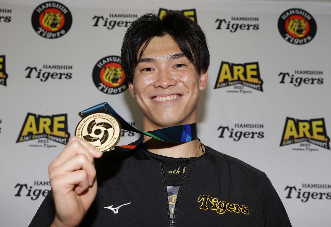 阪神対オリックス　WBCの優勝メダルを手に笑顔を見せる阪神湯浅（撮影・前田充）
