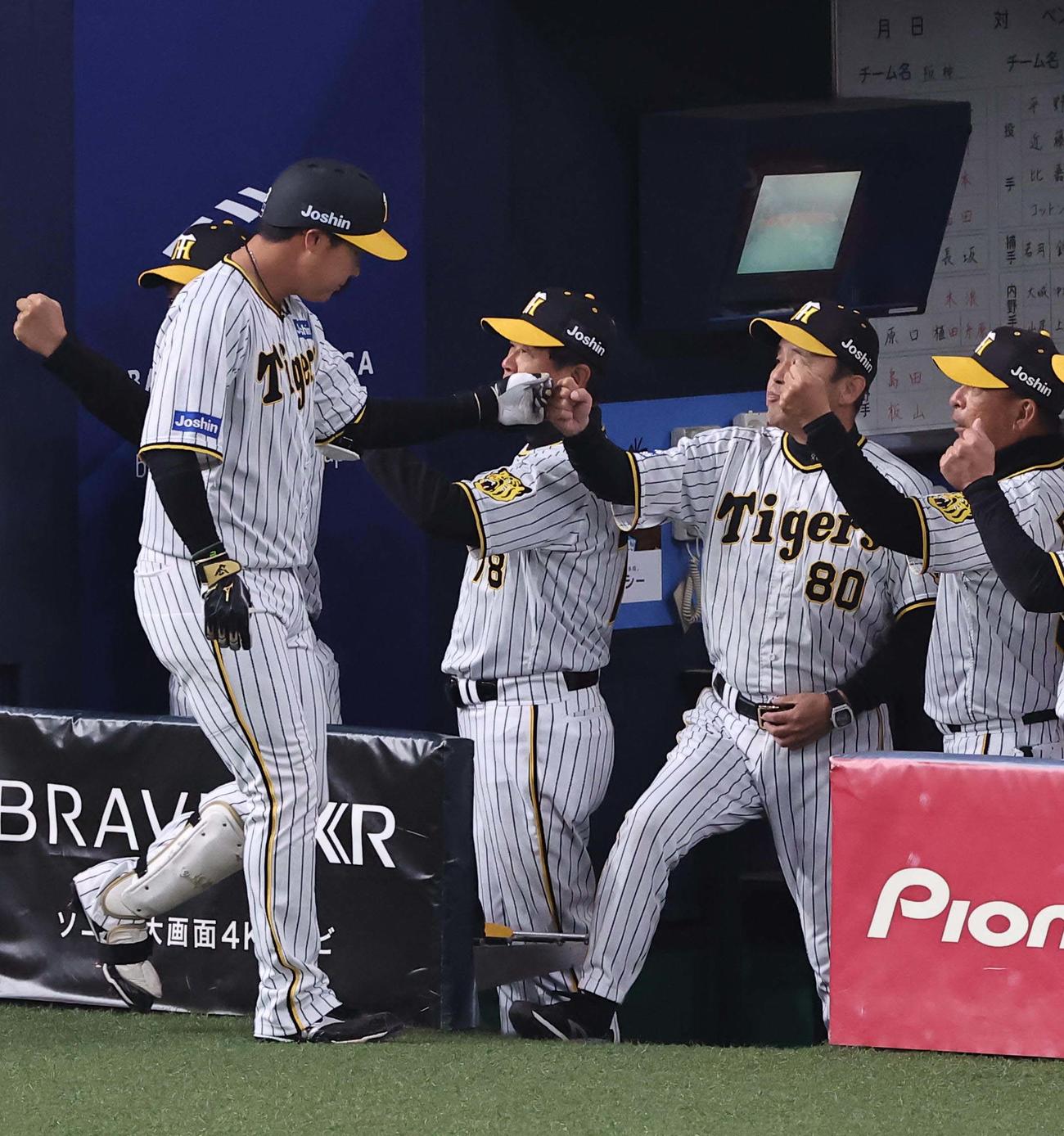阪神対オリックス　1回裏阪神1死一、三塁、岡田監督（右から2人目）は左越え3点本塁打を放った大山をグータッチで出迎える（撮影・上田博志）