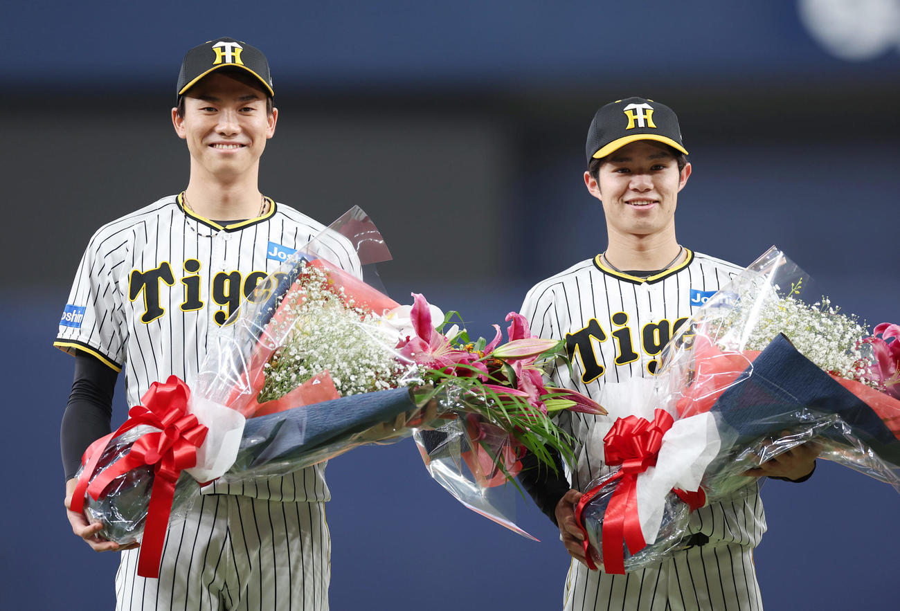 阪神対オリックス　侍ジャパンからの凱旋（がいせん）セレモニーで花束を手に笑顔を見せる阪神湯浅（左）と中野（撮影・前田充）