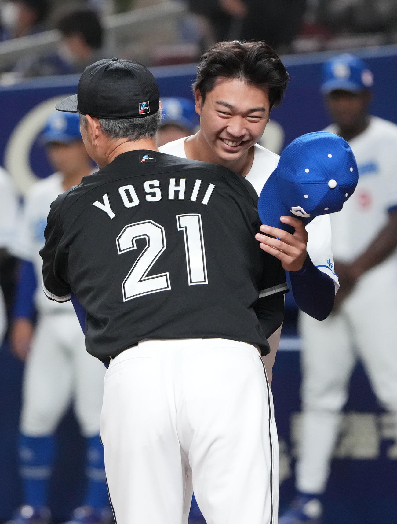 試合前、セレモニーで吉井監督とハグを交わす高橋宏（右）（撮影・森本幸一）
