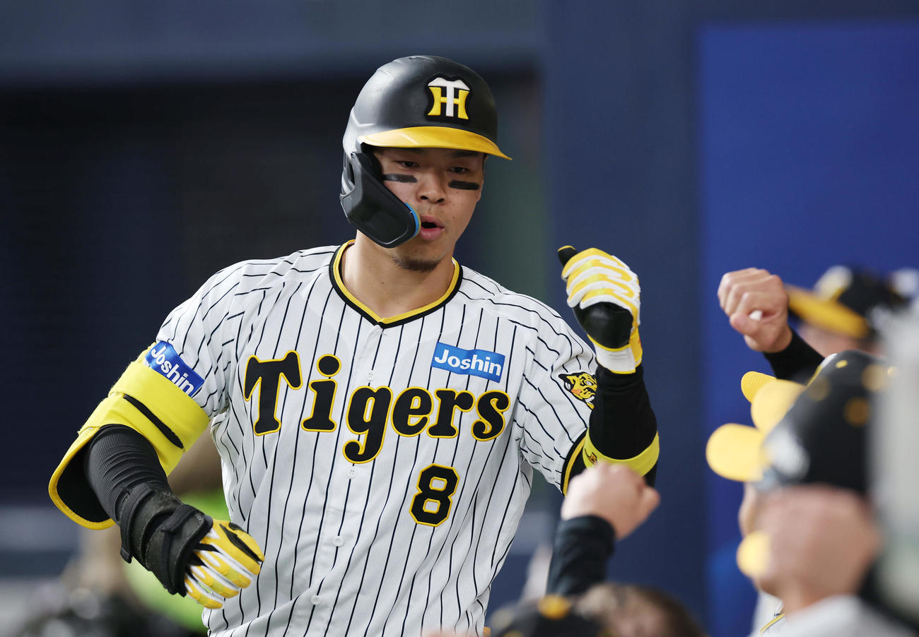 阪神対オリックス　4回裏阪神無死、左中間へソロ本塁打を放ち、ナインに迎えられる佐藤輝（撮影・前田充）