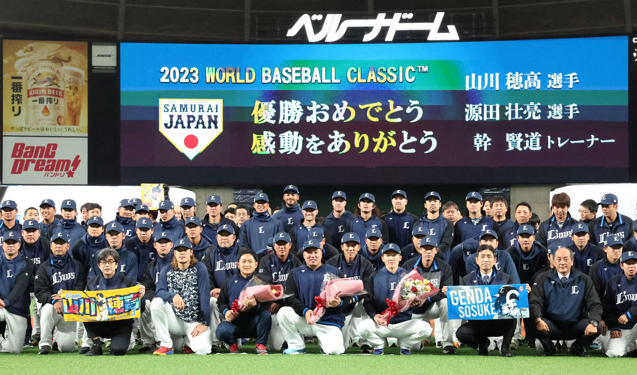 WBCで優勝し花束を手にチームスタッフと写真に納まる、前列中央左から幹トレーナー、山川、源田（撮影・丹羽敏通）