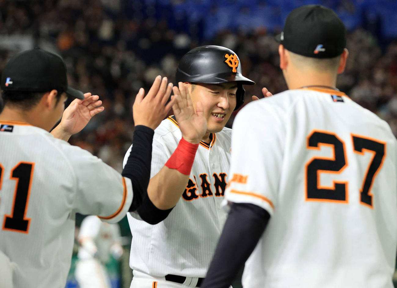巨人対楽天　2回裏巨人1死一、二塁、坂本の左越え先制2点適時二塁打で生還した岡本和（中央）は笑顔でナインとハイタッチ（撮影・浅見桂子）