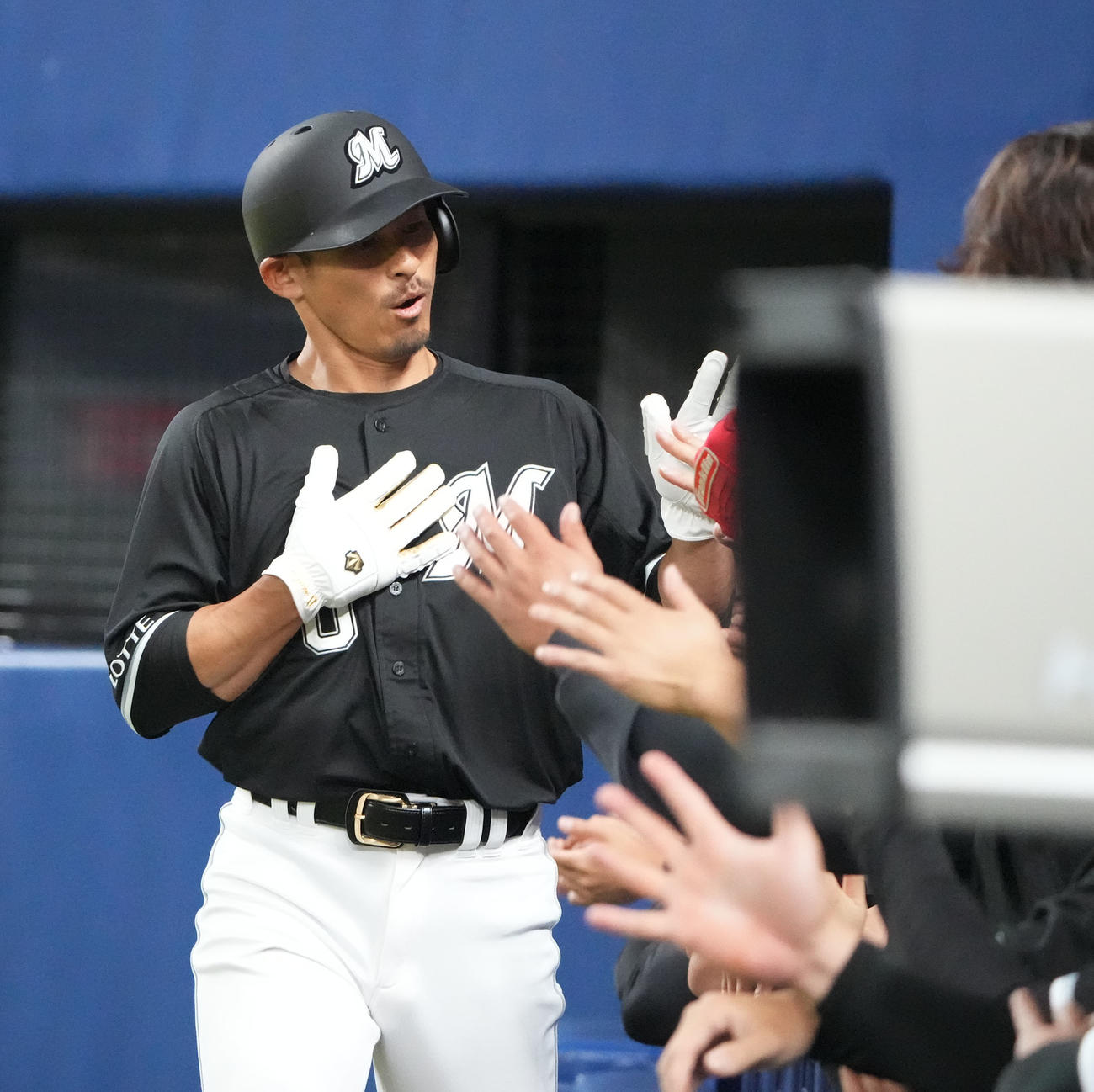 中日対ロッテ戦　1回表ロッテ無死1塁、中村奨の左中間二塁打で生還しナインとタッチを交わす荻野（撮影・森本幸一）