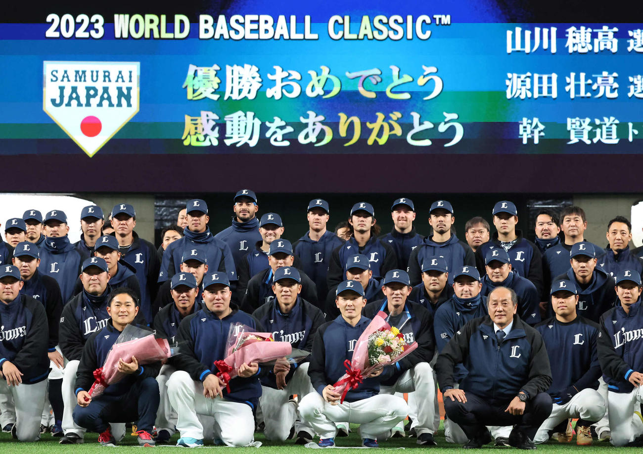 WBCで優勝し花束を手にチームスタッフと写真に納まる、前列中央左から幹トレーナー、山川、源田（撮影・丹羽敏通）