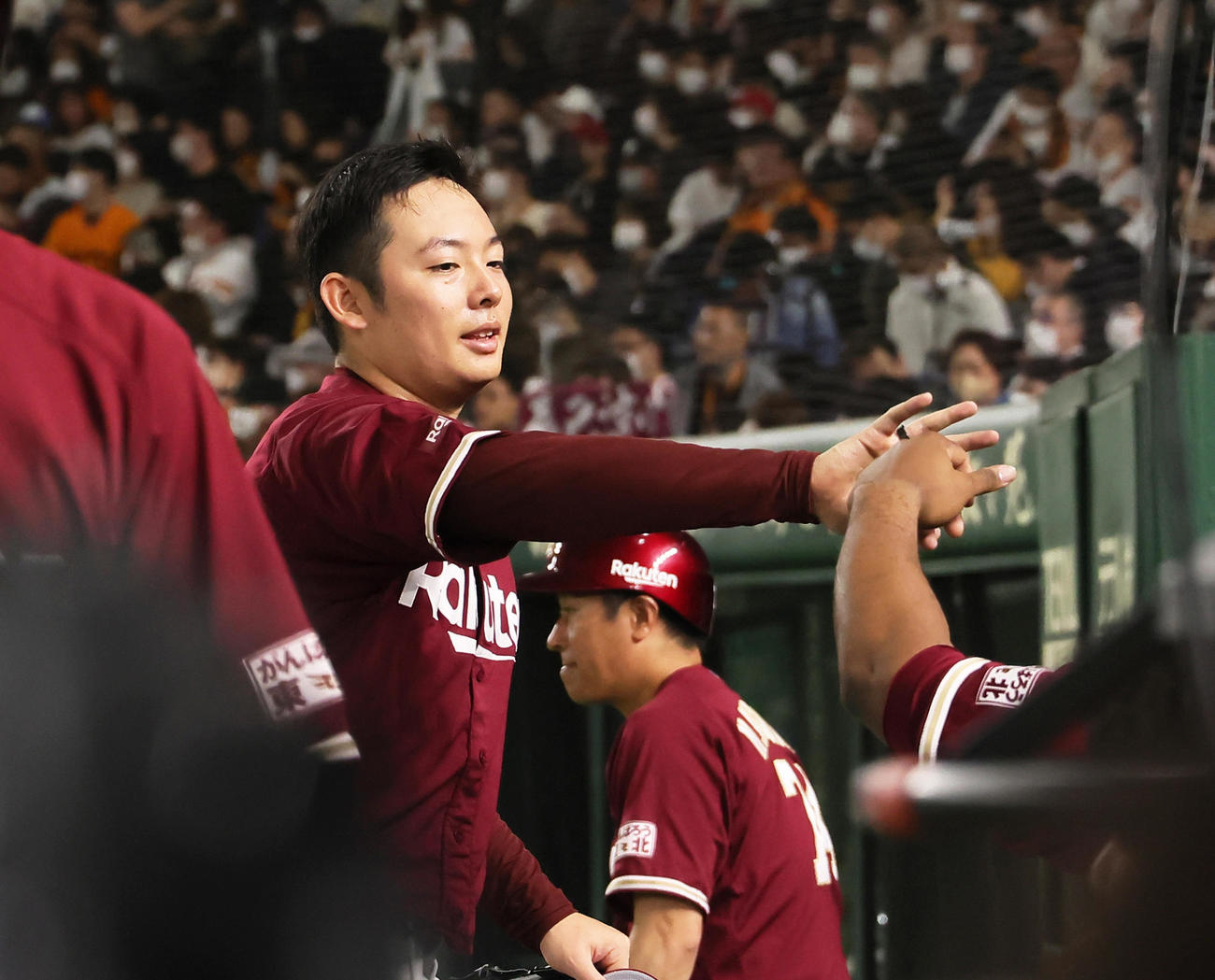 巨人対楽天　8回から登板し、1イニングを無失点で終えタッチを交わす楽天松井裕（撮影・足立雅史）