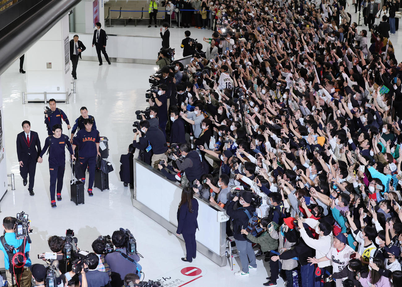 帰国し、大勢のファンの出迎えを受ける日本の佐々木（左から2人目）と高橋宏（同3人目）（2023年3月23日撮影）