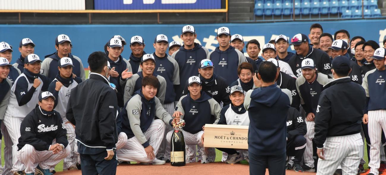 WBC優勝を祝して高津監督から贈られた9リットルのシャンパンを手に記念撮影に納まるヤクルトの選手たち。前列中央左から村上、山田、中村（撮影・鈴木正章）