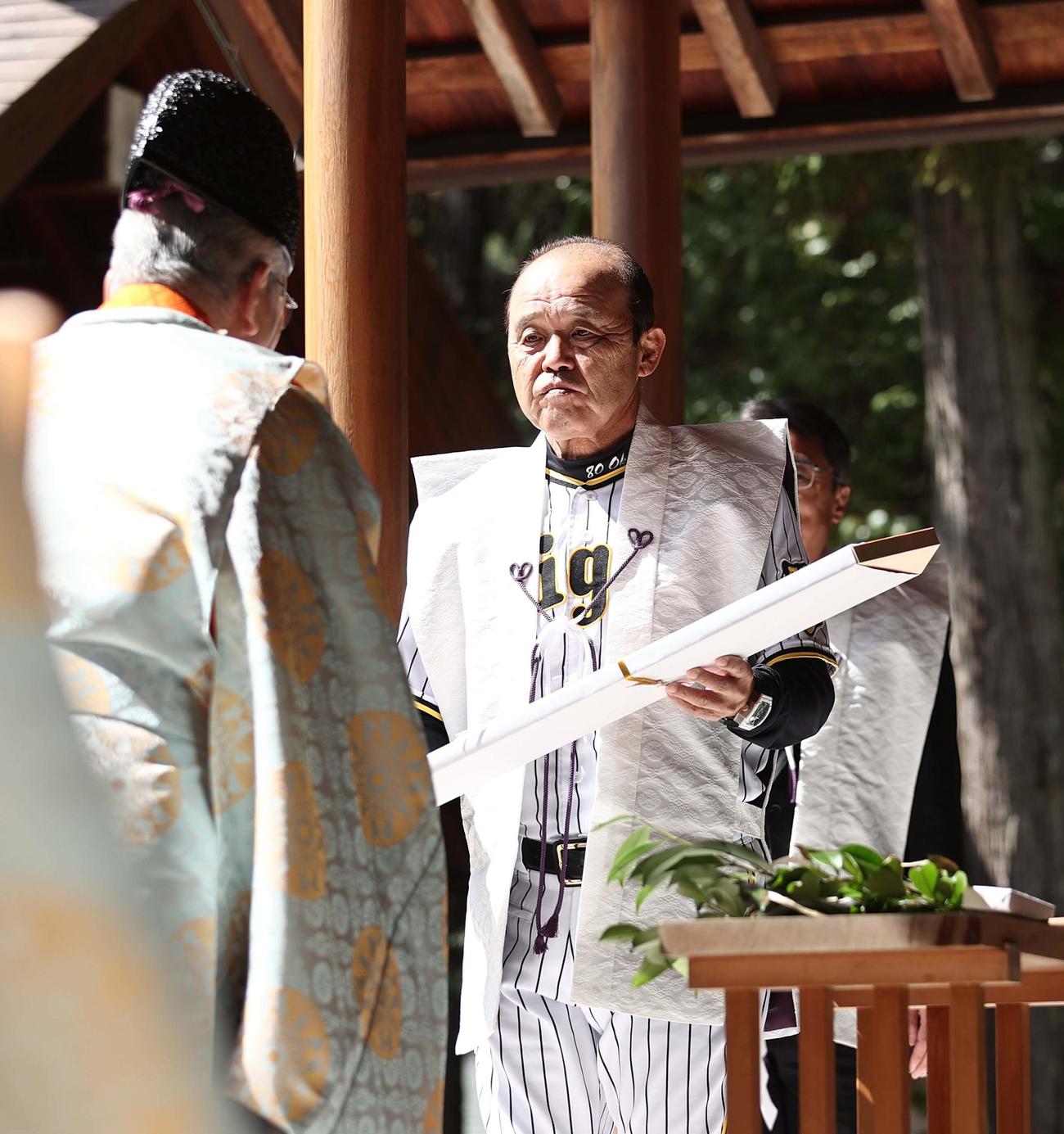 広田神社で必勝祈願をする阪神岡田監督（右）は宮司の西井さんから必勝守護の木札を受け取る（撮影・上田博志）
